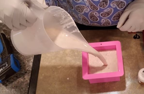 Adding melt and pour soap base into silicone mold