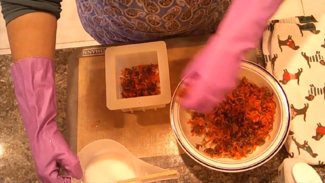 Adding red and brown confetti to the white soap