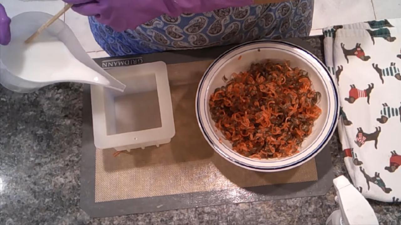 Pouring white shea butter soap into a square mold