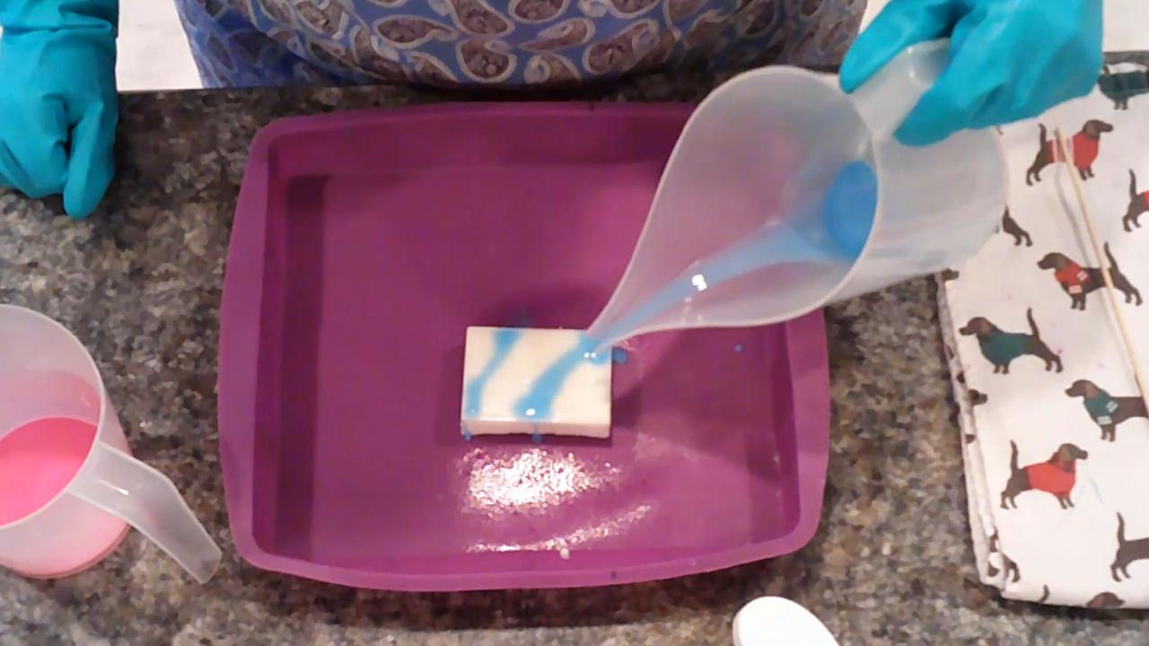 Drizzling blue soap over the white bar