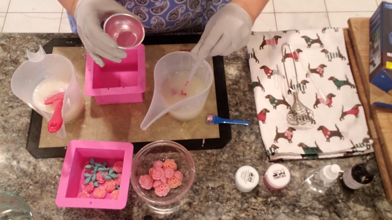Squirting pink mica into white soap in the mold for a subtle swirl