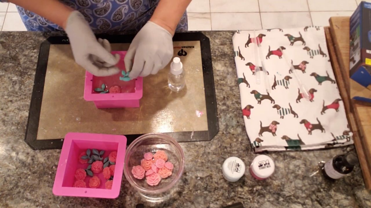 Placing rose and leaf embeds on top of the soap in the mold