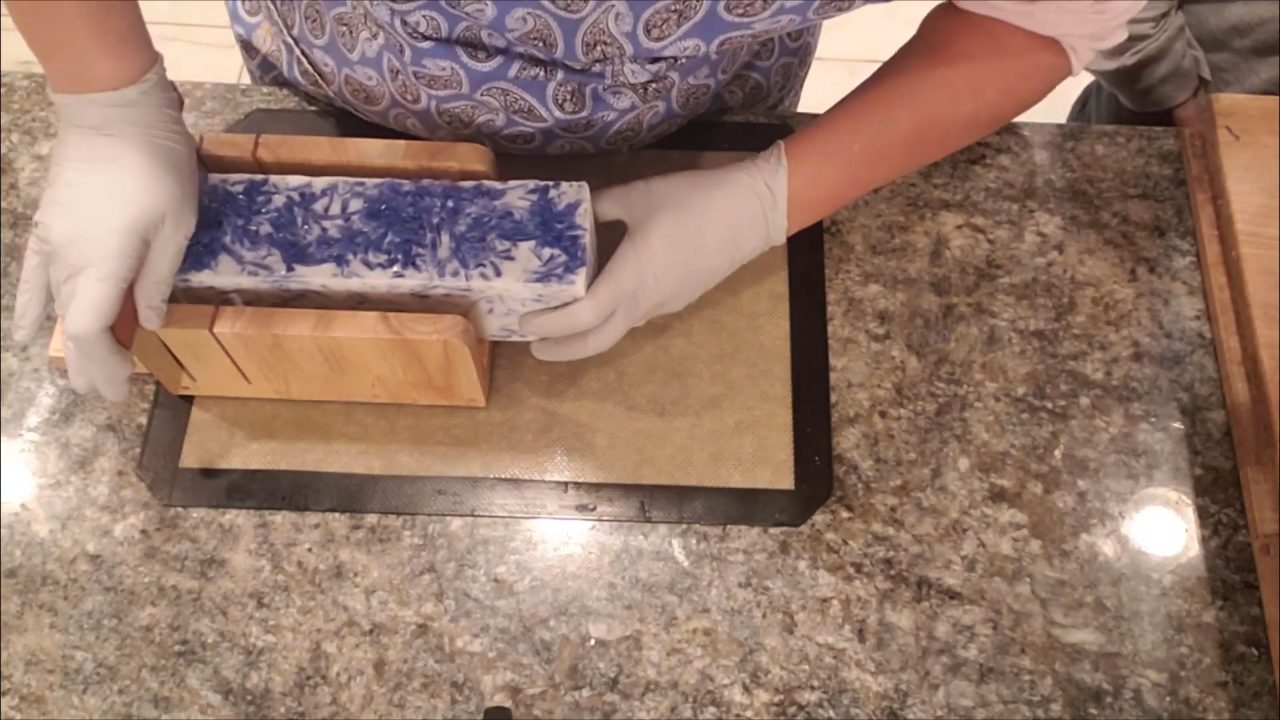Cutting the blue confetti soap loaf in a soap cutter