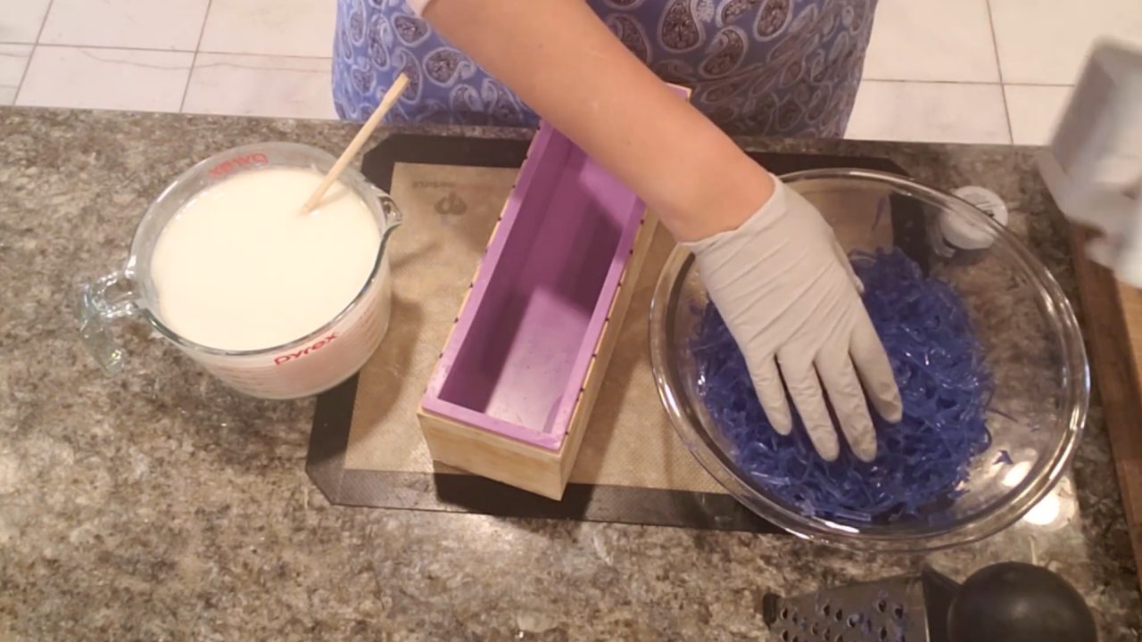 Pouring a layer of white soap into a purple loaf mold