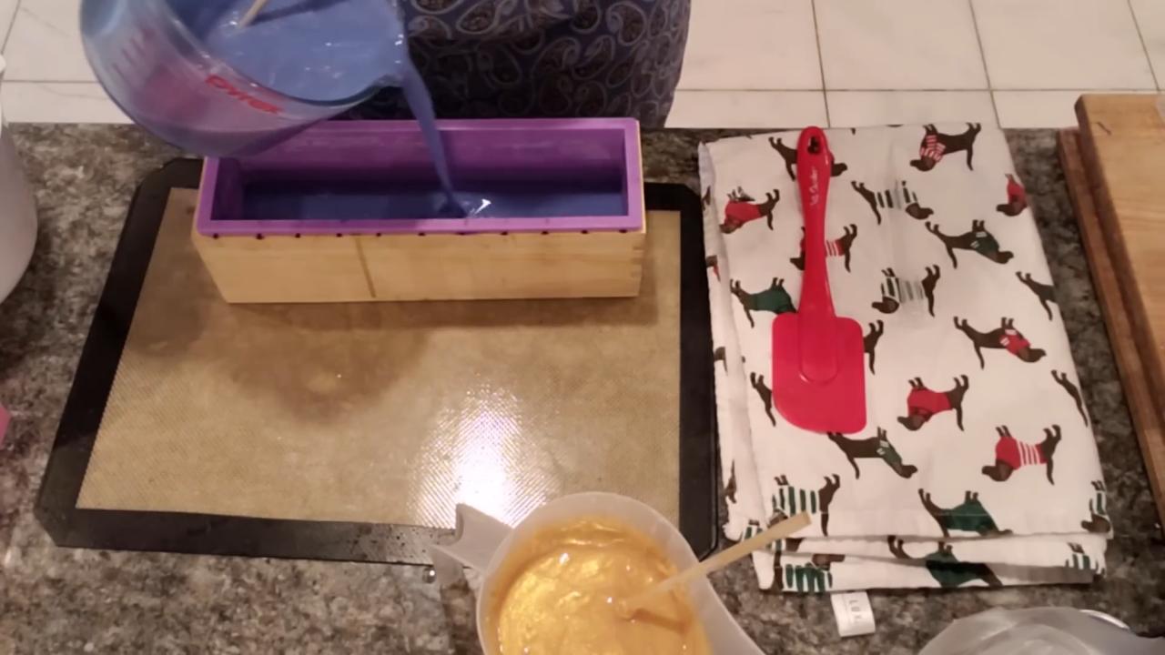 Pouring thick blue soap into a loaf mold