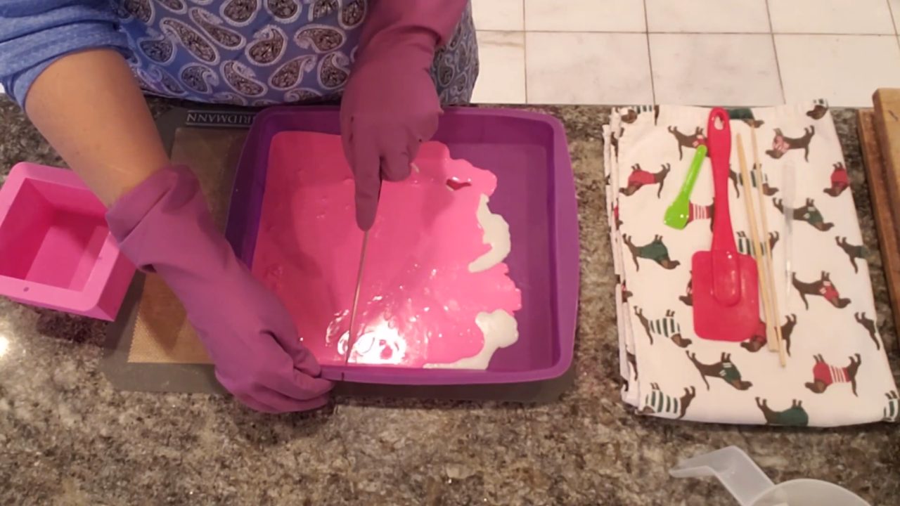 Cutting the layered pink and white soap into strips