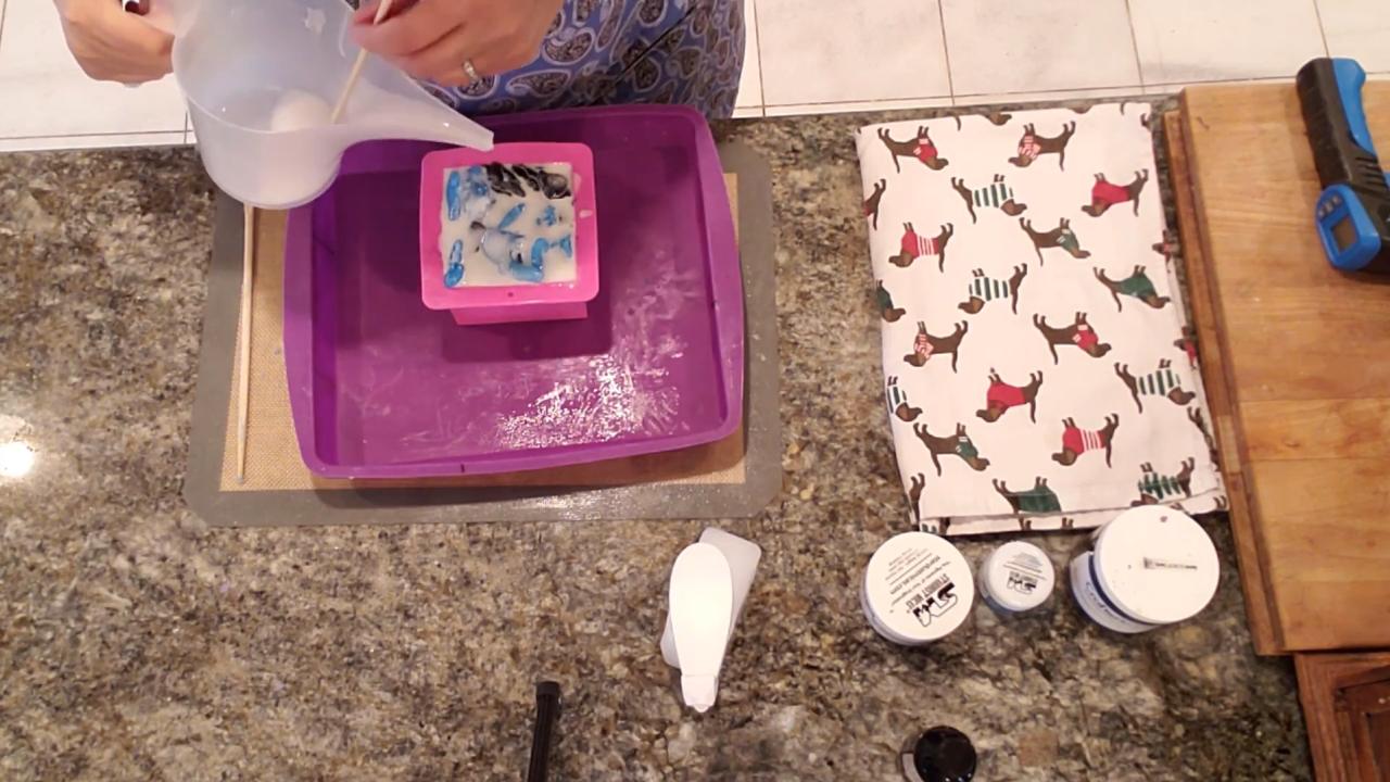 Pouring white soap over the torn pieces in the mold