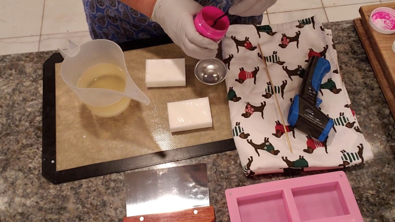 Mixing hot pink mica into melted opaque melt and pour soap