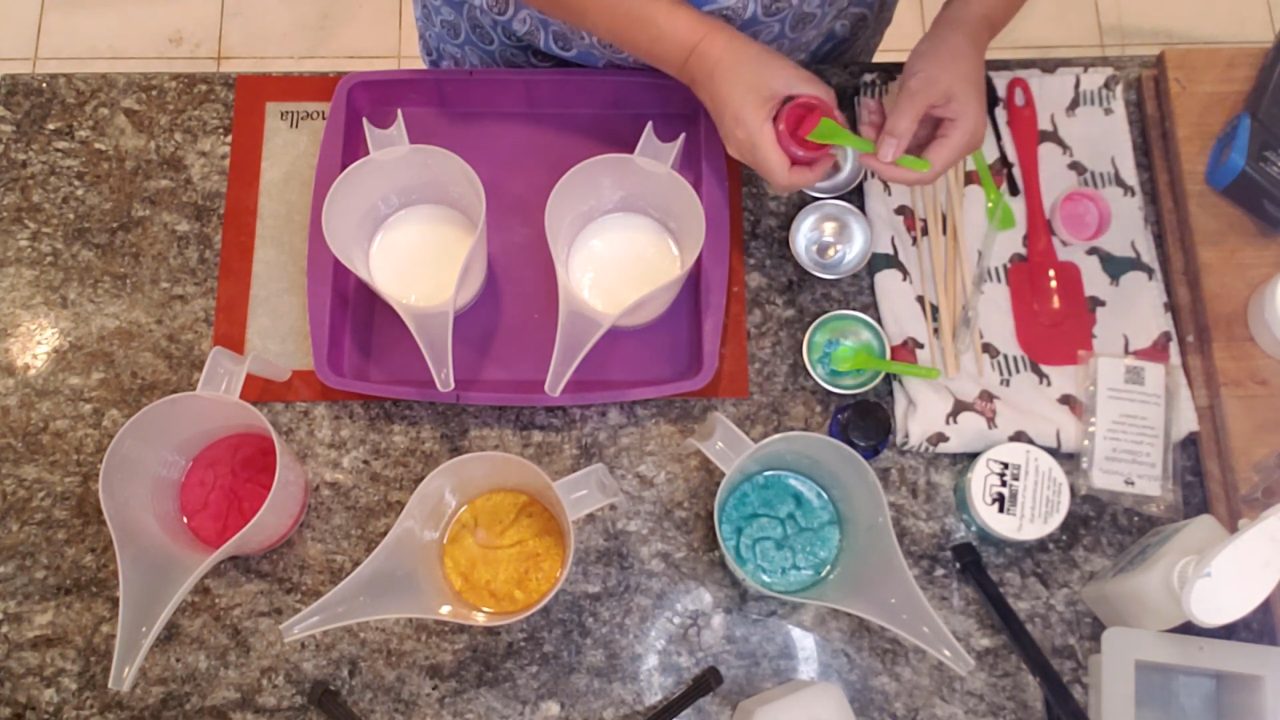Remelted red, gold and green soap in pour cups with white shea butter