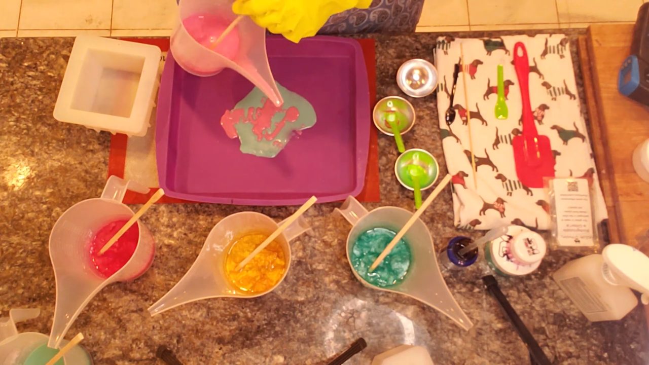 Pouring red and green soap in short layers on a silicone tray