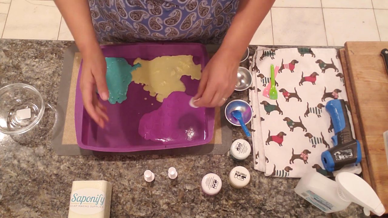 Thin sheets of purple, green and yellow soap set in a silicone pan