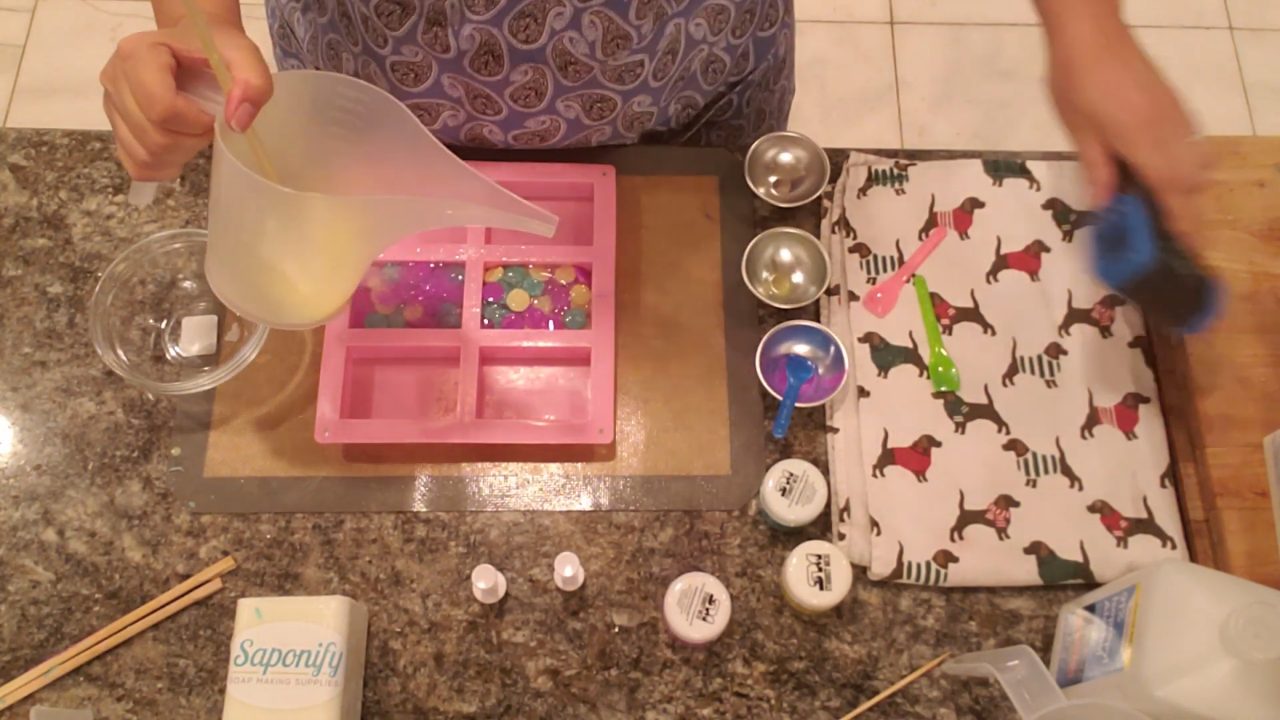 Pouring a yellow layer on the back of the circle embed soaps