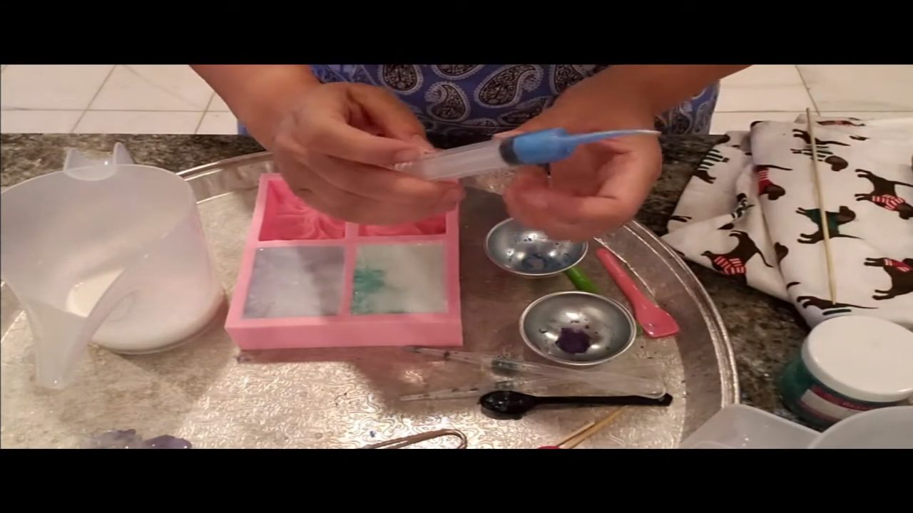 Swirling blue mica into goats milk soap in a cloud wave mold
