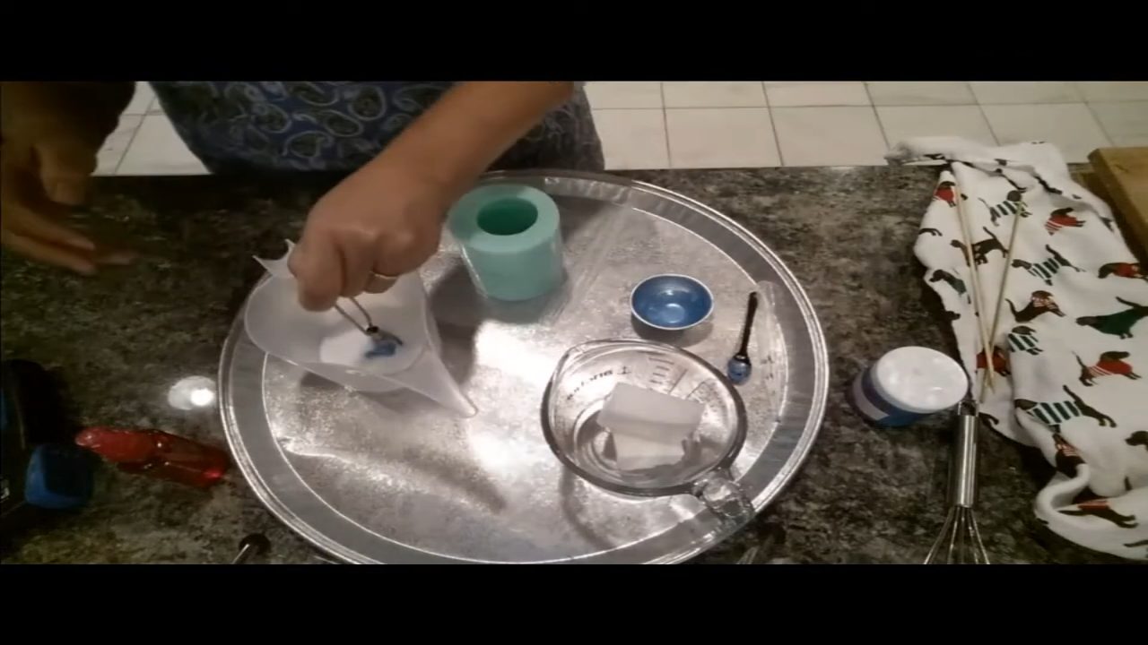 Pouring swirled blue frosting soap into the cupcake mold