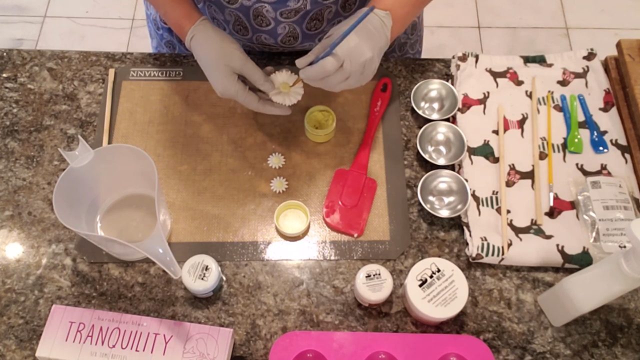 Dry brushing mica onto daisy soap embeds with a paintbrush