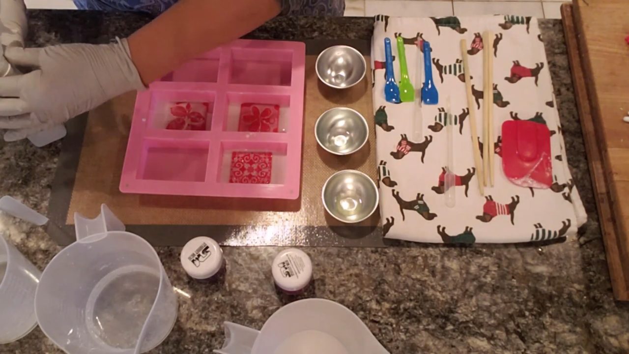 Scraping white soap off the raised areas of the embossing stamp with a spatula