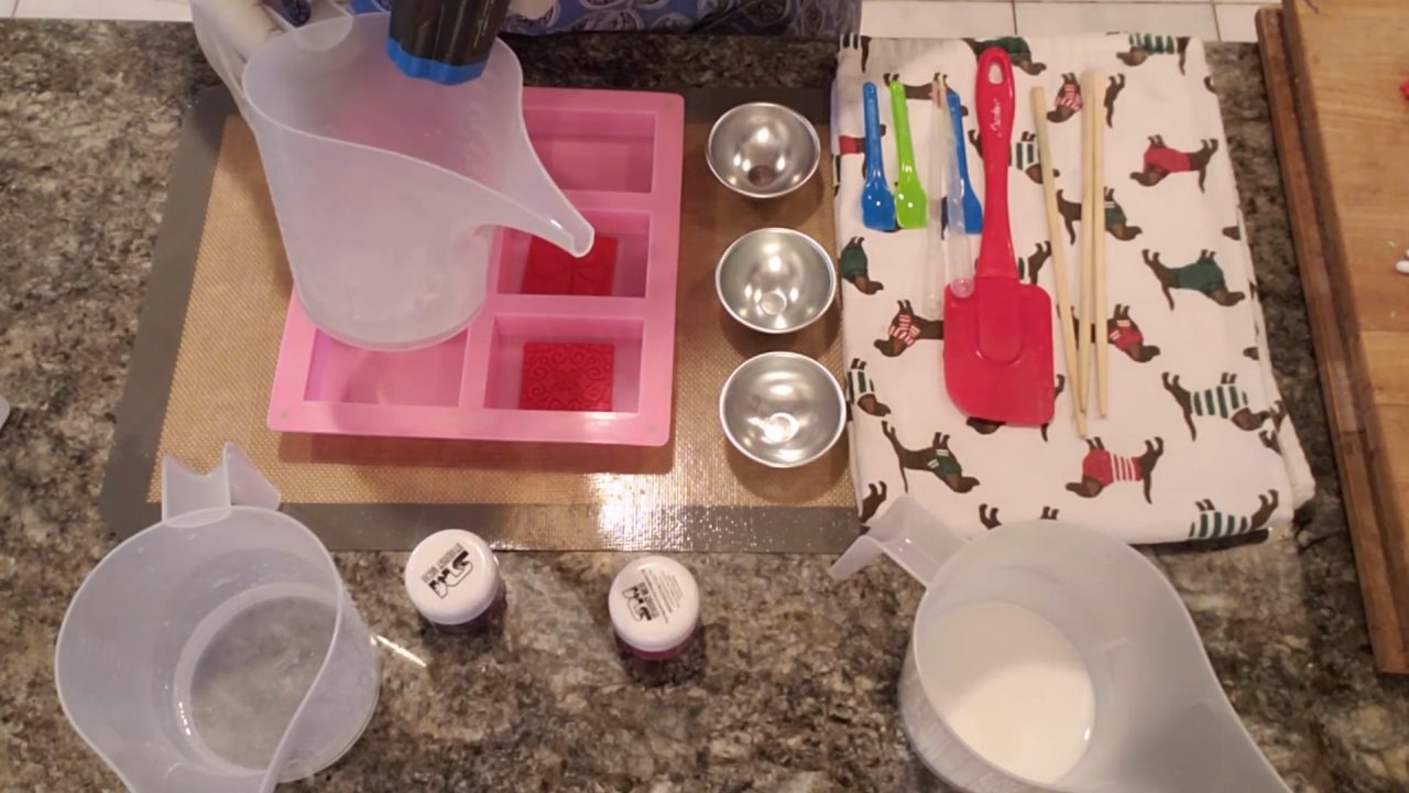 Soap embossing stamps placed in the bottom of a pink 6 cavity silicone mold