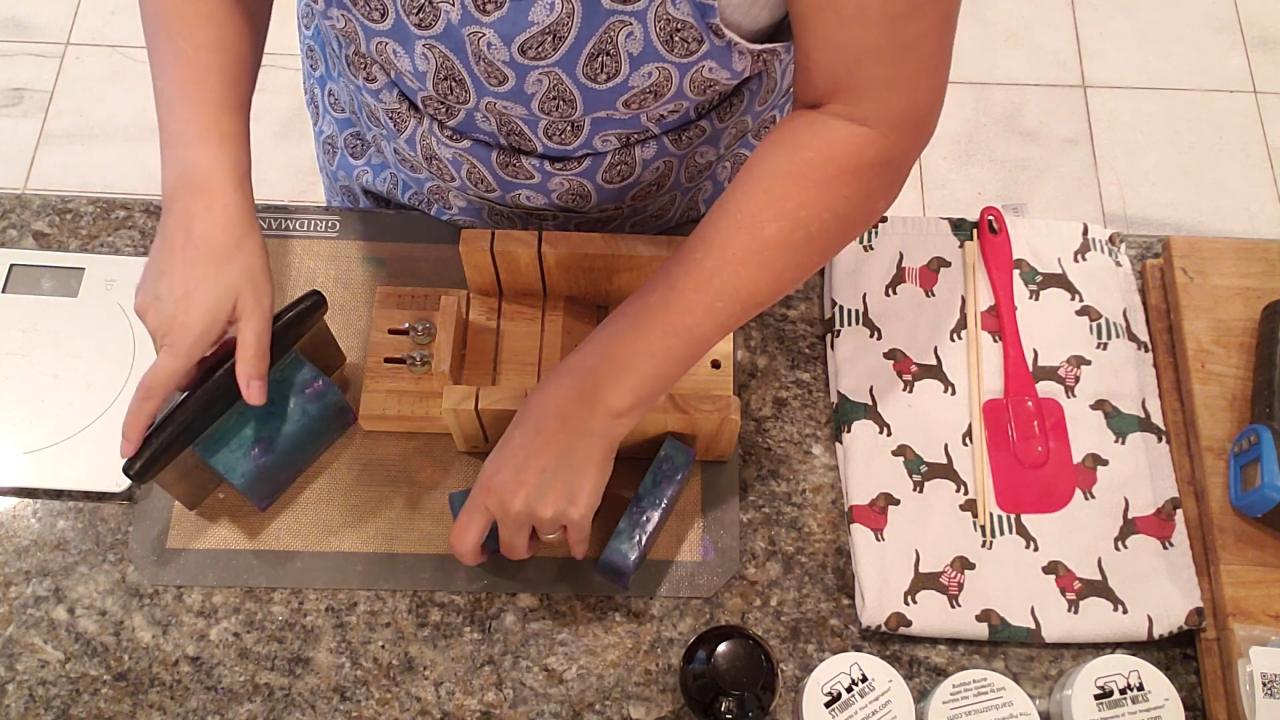 Cutting the purple and green soap loaf into bars