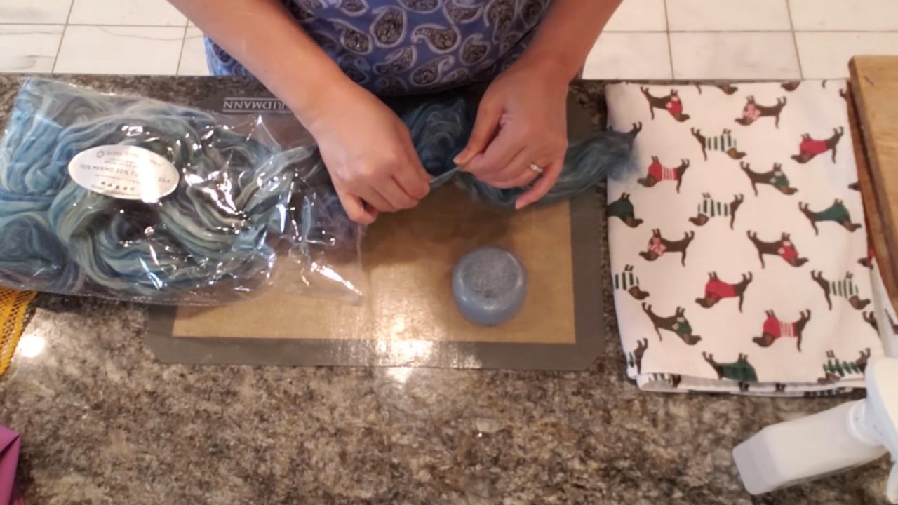 Gently pulling apart multicolor wool roving