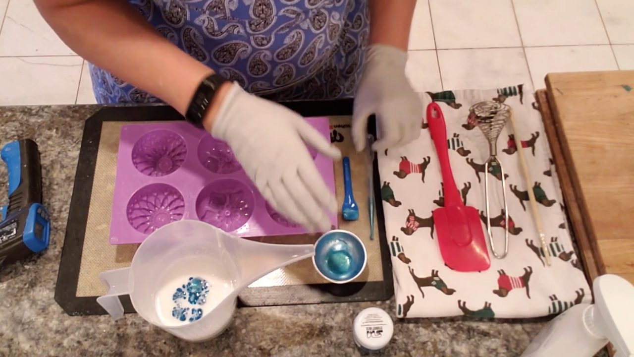 Swirling blue color into the soap with a coil whisk