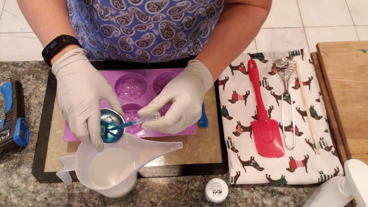 Squirting blue mica into cooled shea butter soap