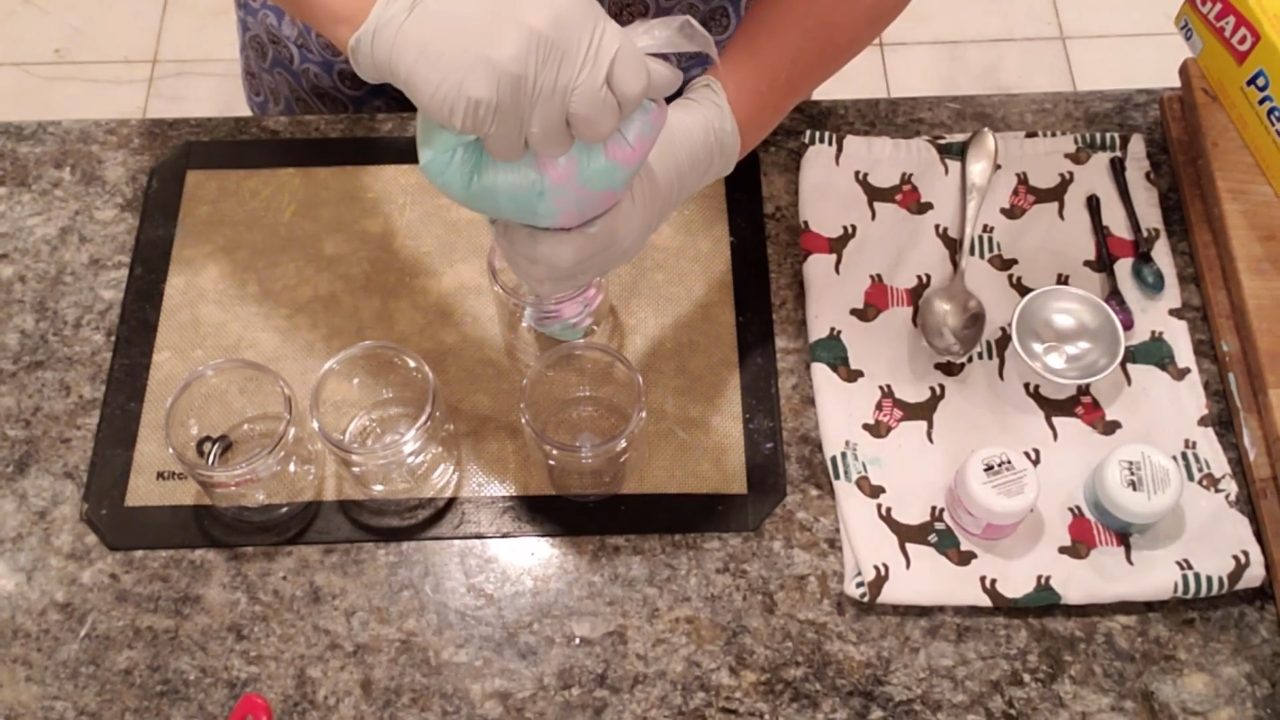Piping colorful foaming bath butter into a jar
