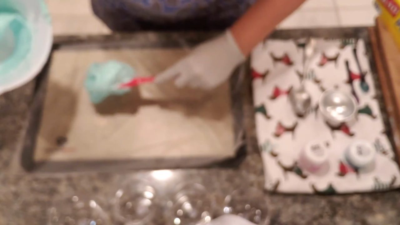Spooning colored whipped soap onto press and seal wrap