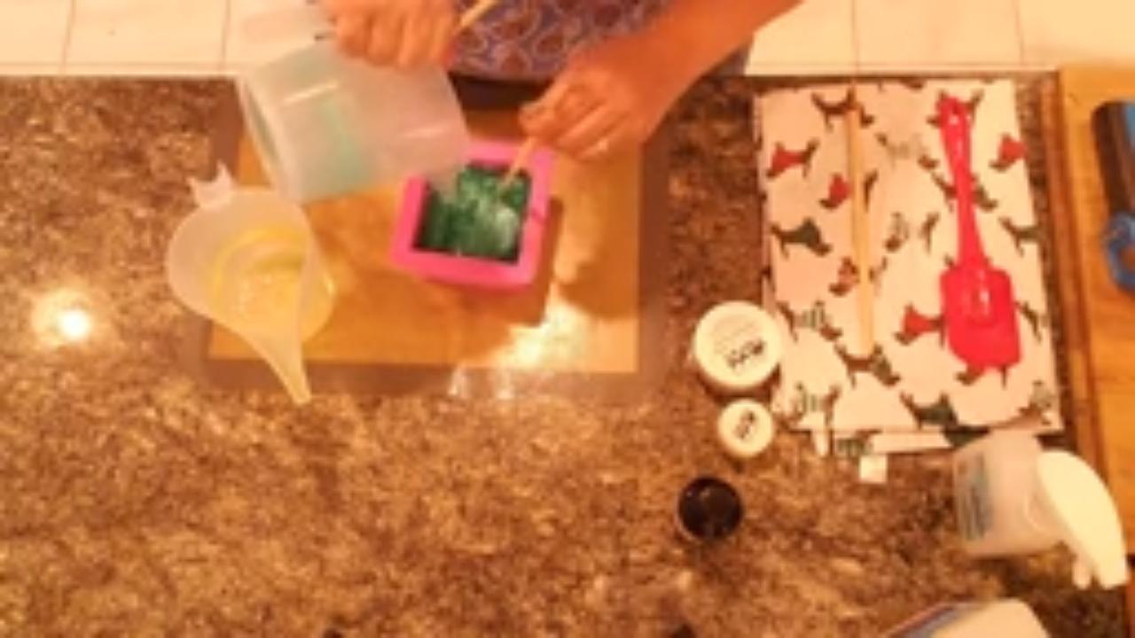 Filling the square mold with green and yellow soap