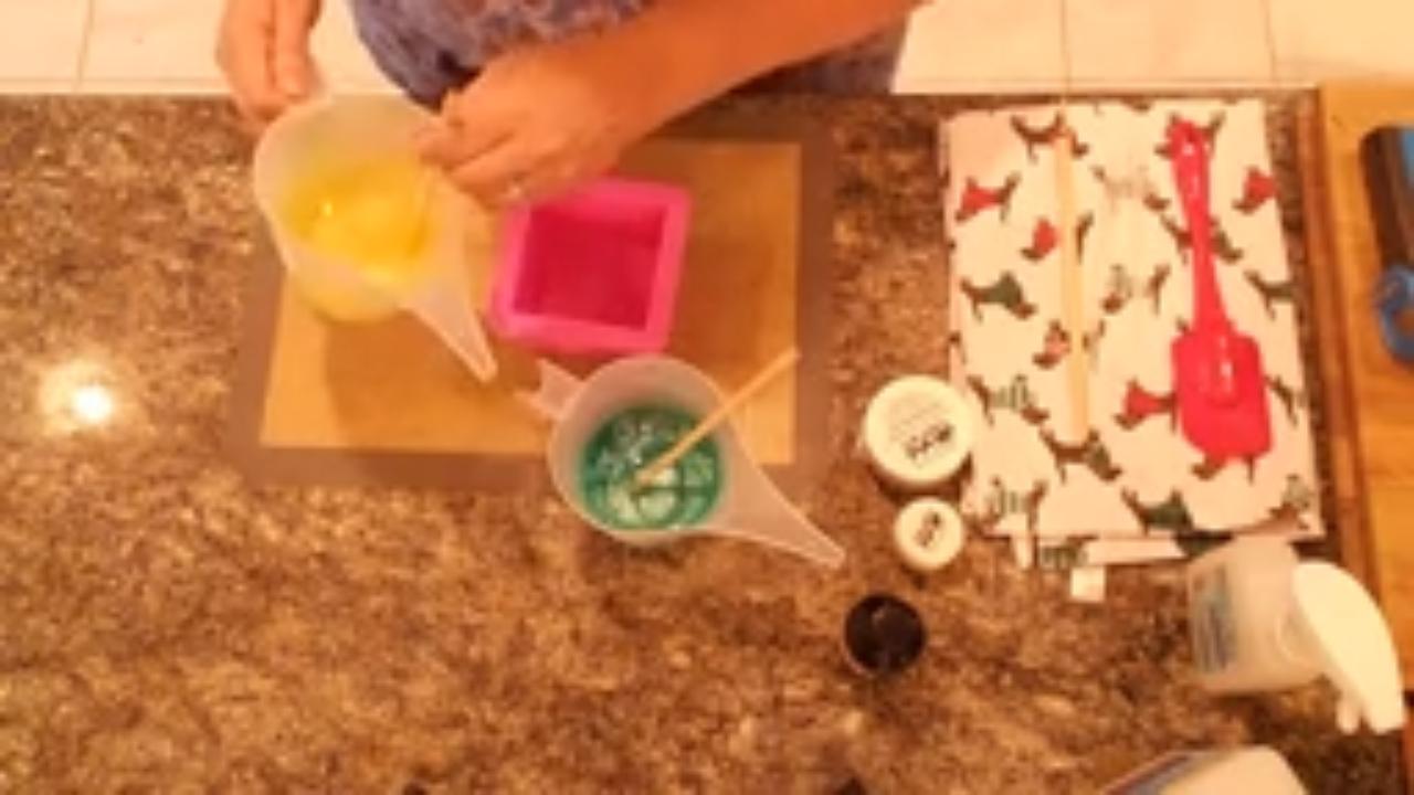 Pouring yellow and green soap into the mold together