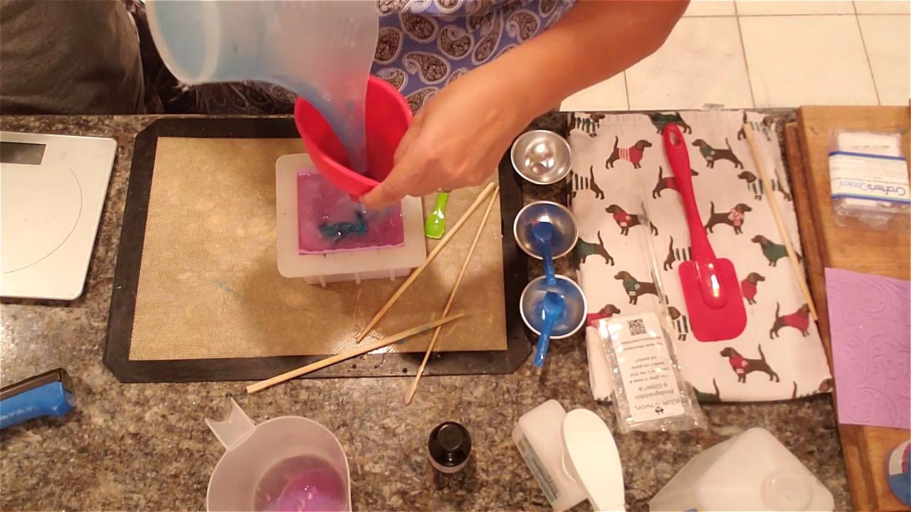 Pouring remelted pink soap through the funnel
