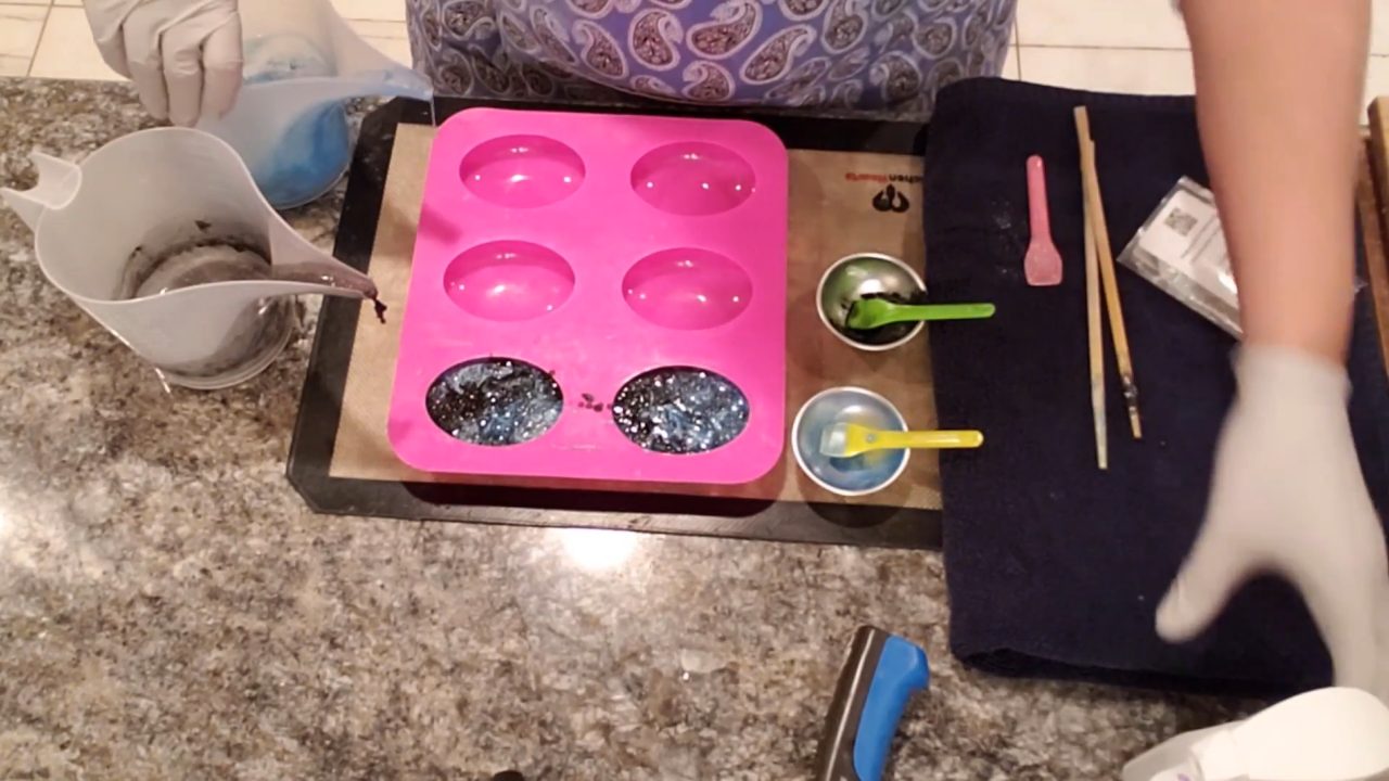 Black and blue galaxy soap poured into the oval mold cavities