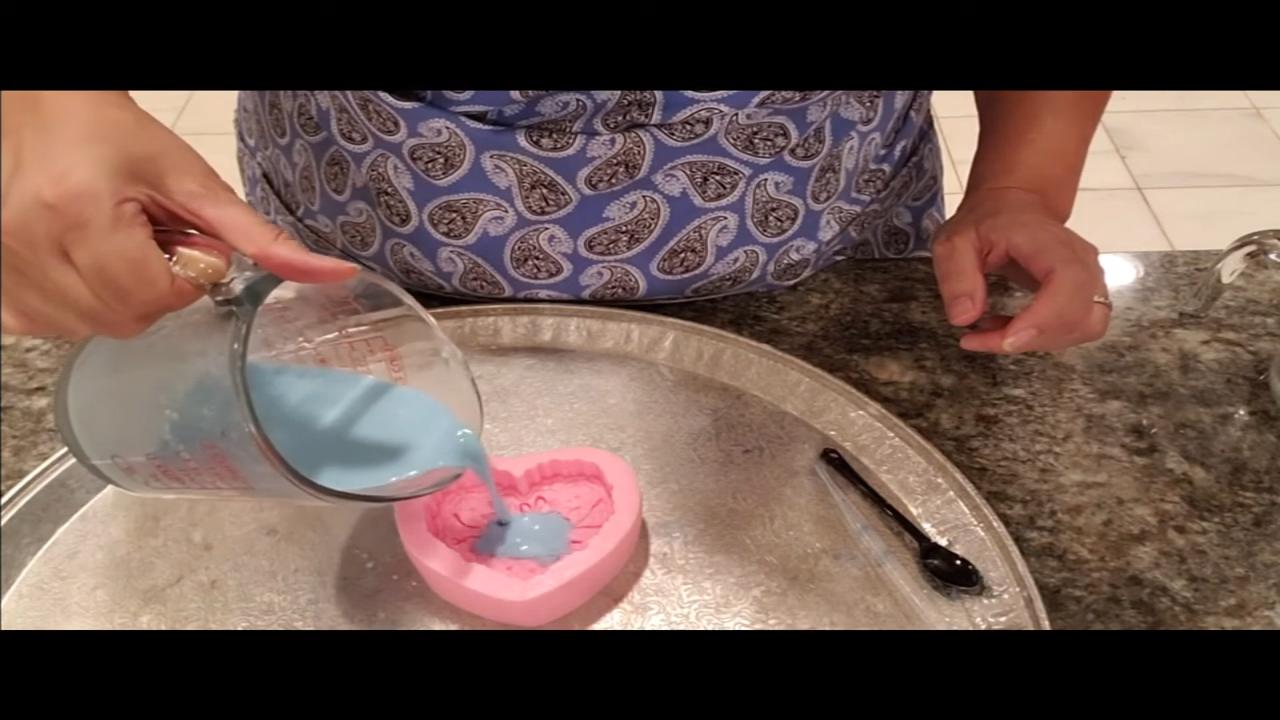 Pouring blue goat milk soap into the heart mold