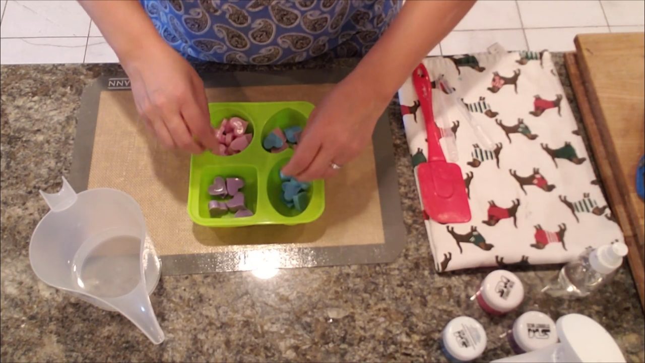 Arranging pink, blue and purple soap hearts in a clear soap base