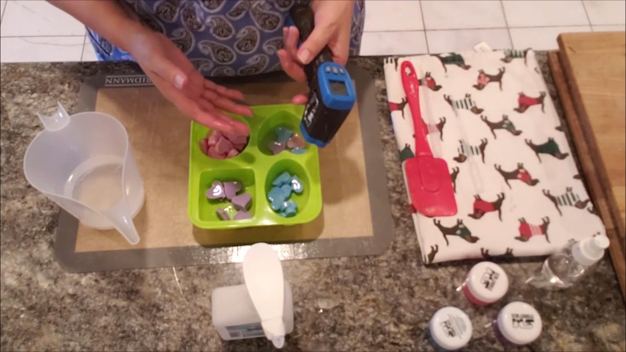 Pouring clear melt and pour soap over the heart embeds