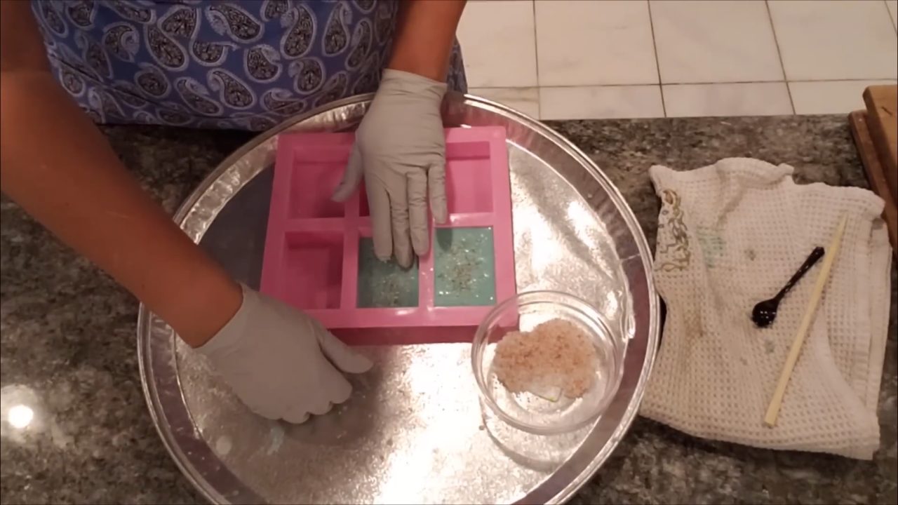 Patting coarse pink Himalayan salt onto the top of the soap