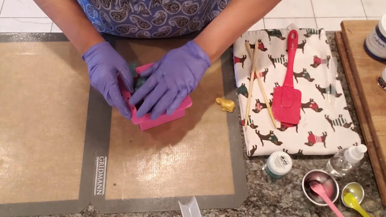 Pressing the rolled soap layers into a square silicone mold
