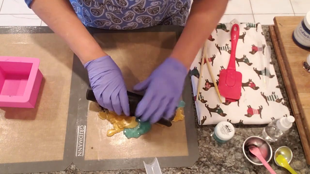 Peeling and rolling the black, gold and green soap layers into a ball