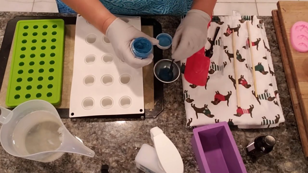 Mixing Blue Lagoon mica into clear melt and pour soap next to ball molds