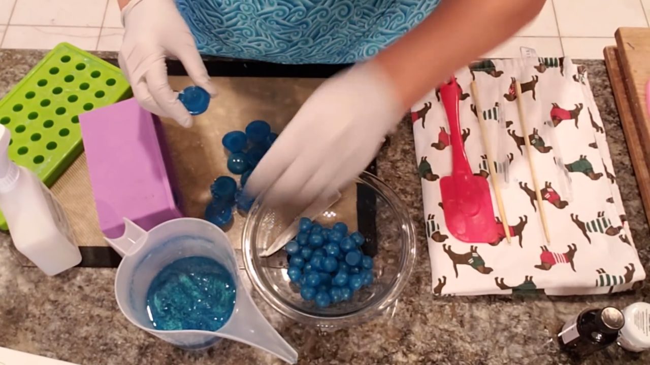 Sticking flat blue soap dots to the inside of a loaf mold