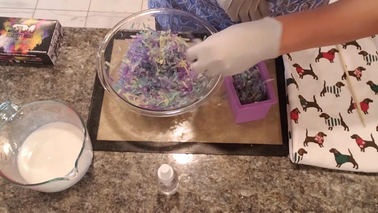 Scooping soap confetti shreds into a small loaf mold
