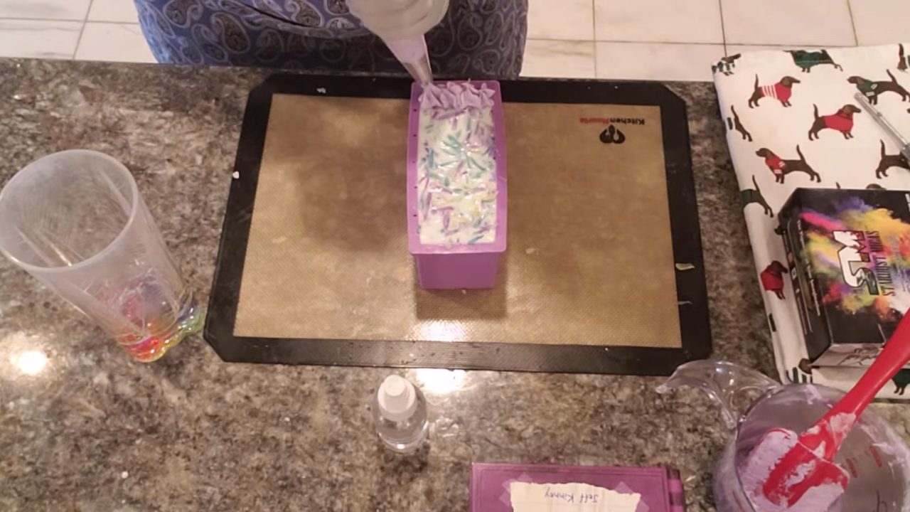 Piping purple Melt Whip and Pipe frosting onto the confetti soap loaf
