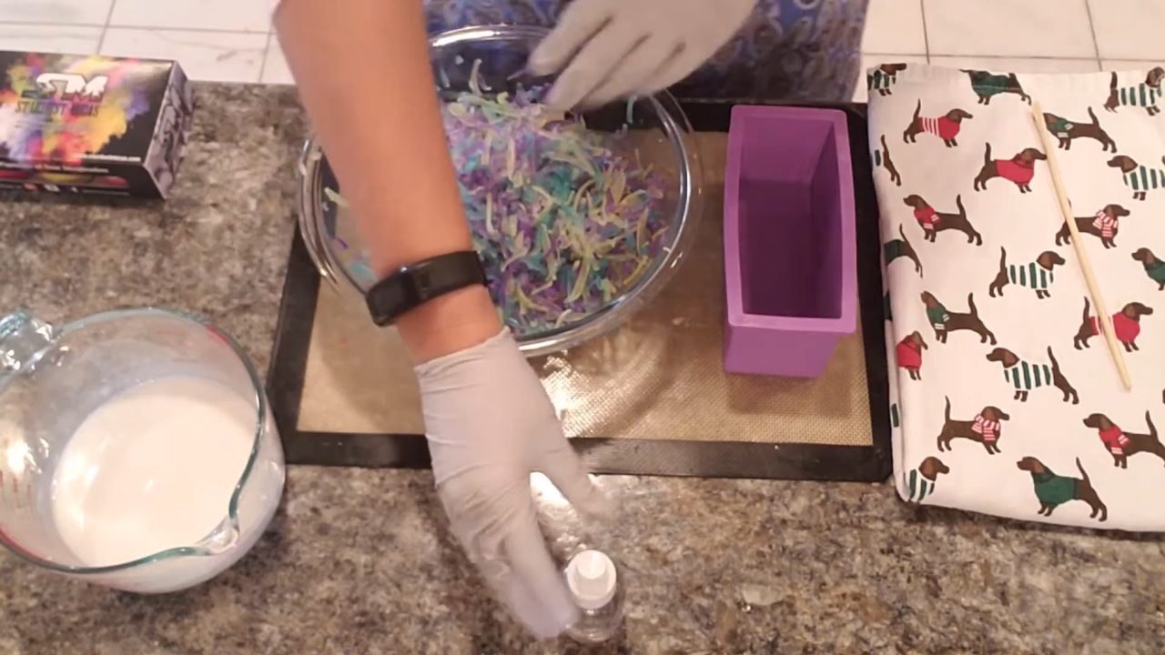 Spraying soap confetti shreds with alcohol next to a loaf mold