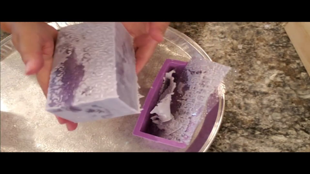 Unmolded lavender soap loaf with the fondant mat peeled from the sides