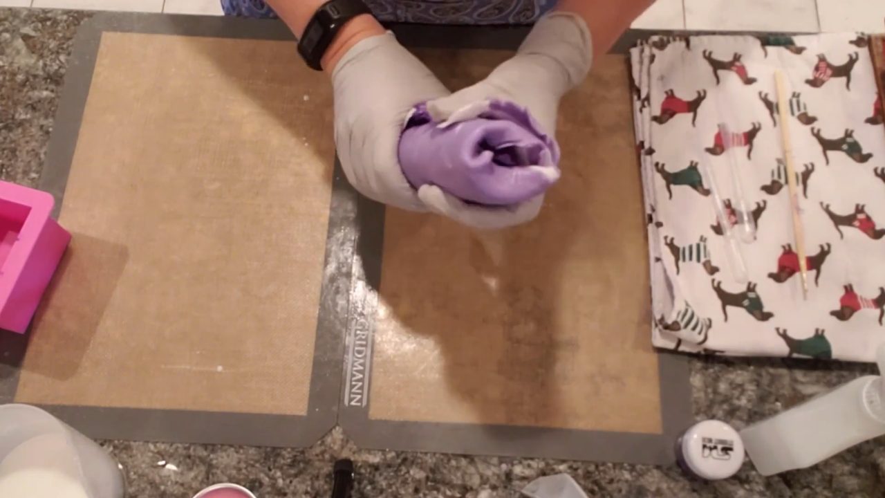 Rolling the purple and white soap layers into a ball