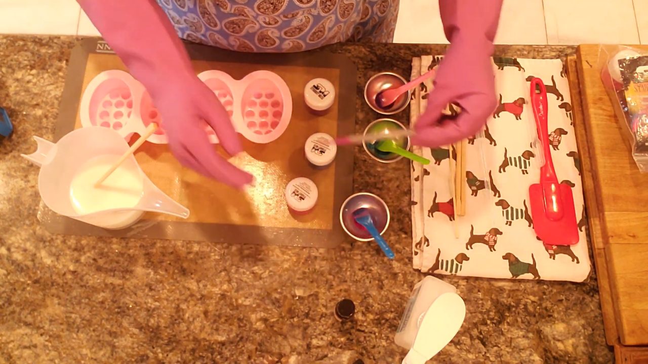 Dropping mica into the holes of a massage bar mold with a pipette