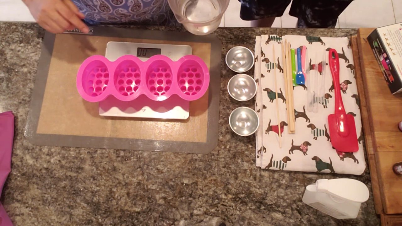 Pink silicone massage bar soap mold with raised nubs on a scale