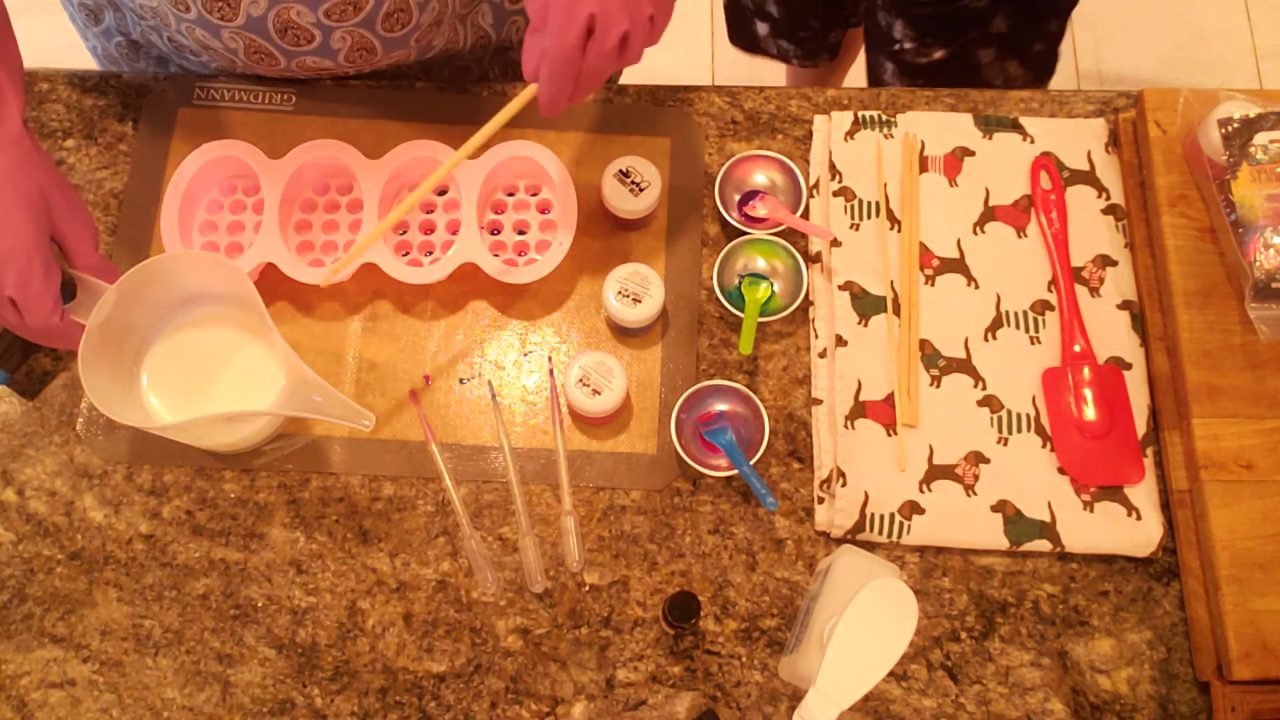 Pouring white shea butter melt and pour soap into a massage bar mold