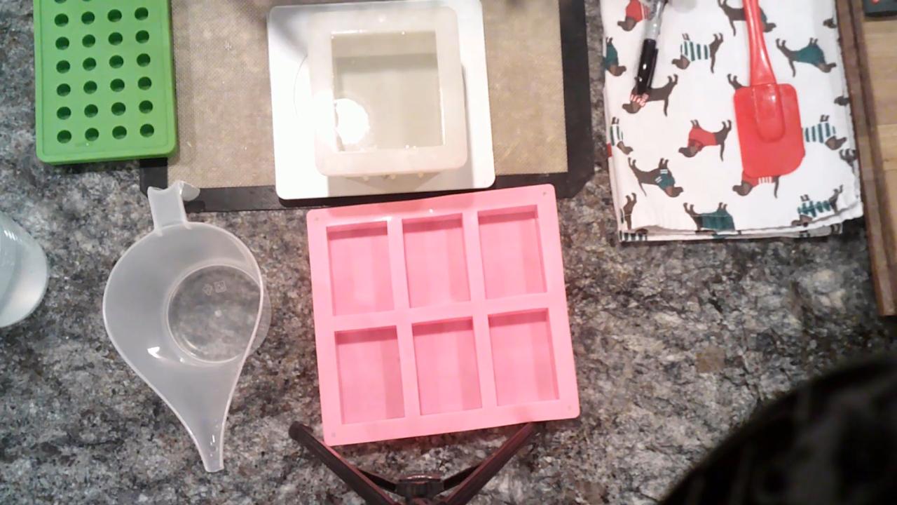 Pouring water into a soap mold on a scale