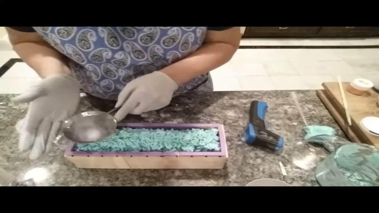 Sprinkling glitter over the soap frosting with a small strainer