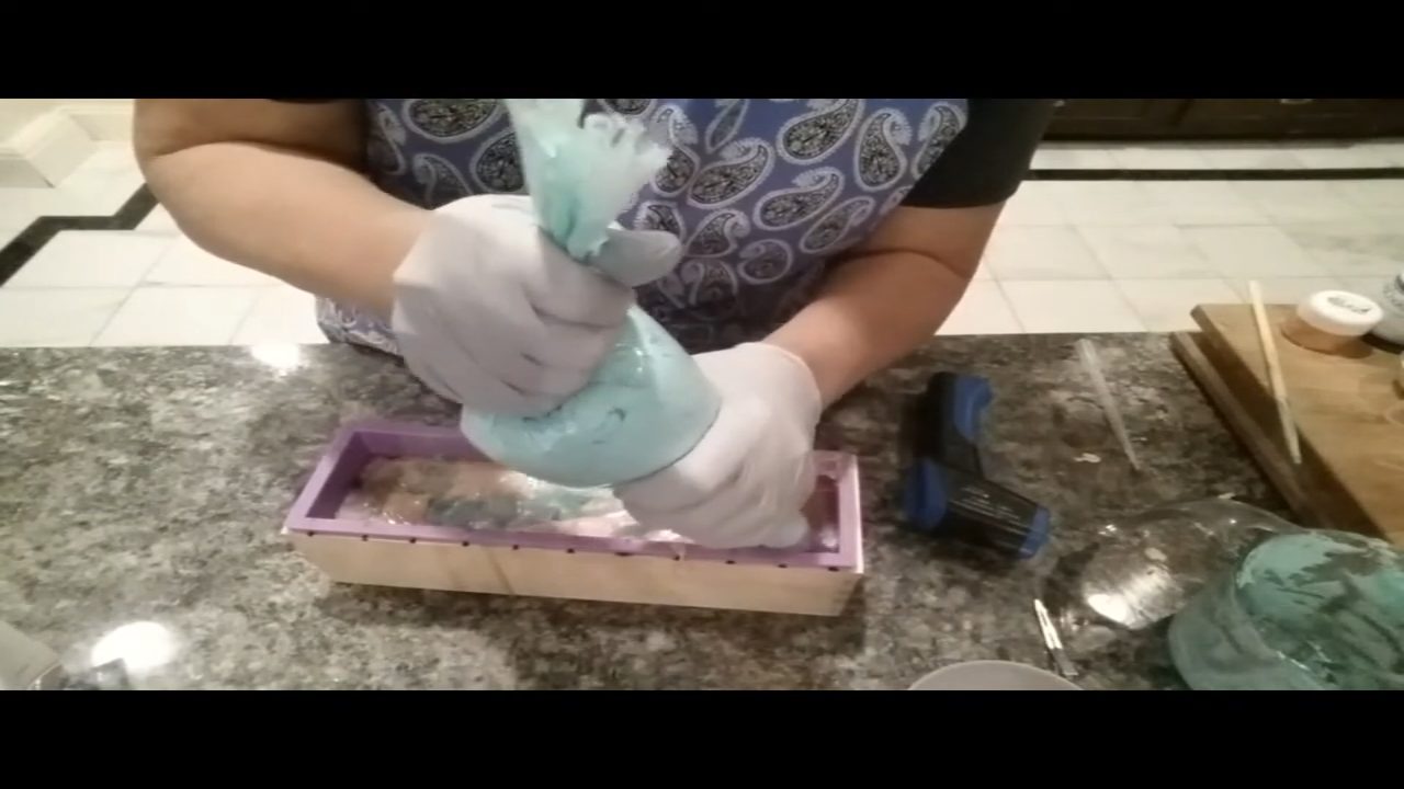 Starting to pipe blue Melt Whip and Pipe soap frosting onto the loaf